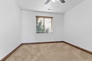 Empty room with carpet flooring and a ceiling fan