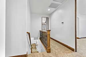 Corridor featuring an upstairs landing, light colored carpet, and recessed lighting