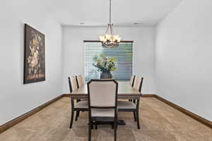 Dining room with carpet flooring and suspended lighting