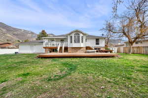 Back of property with a deck with mountain view and brick siding