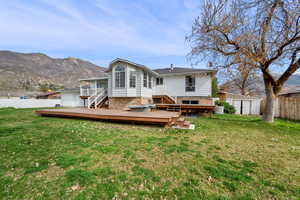 Back of property with a deck with mountain view, a storage unit, and brick siding