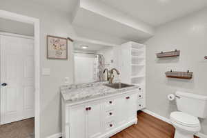 Bathroom with vanity, curtained shower, and light wood-style flooring