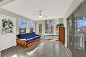 Sitting room with a ceiling fan and light wood-type flooring