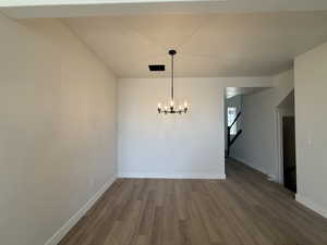 Unfurnished dining area featuring dark wood finished floors and hanging lights