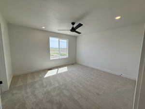 Empty room with carpet flooring, a textured ceiling, recessed lighting, and ceiling fan