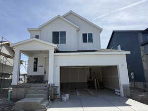 Modern farmhouse style home featuring covered porch, board and batten siding, driveway, an attached garage, and roof with shingles
