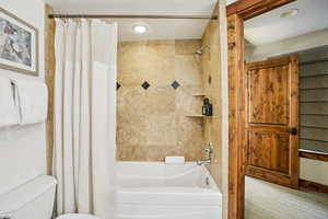 Full bathroom featuring shower / tub combo and carpet flooring