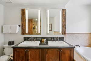 Bathroom featuring double vanity and a bath