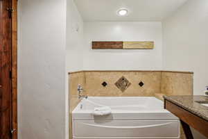 Full bath with vanity and a garden tub