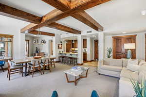 Living room featuring beamed ceiling, light colored carpet, and recessed lighting