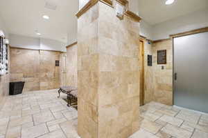 Bathroom with stone tile floors, recessed lighting, and a walk in shower
