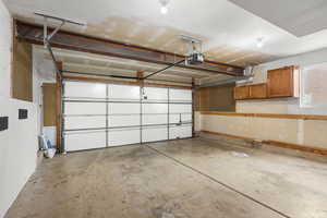 Spacious 2-car garage with built-in shelving, workbench area, and ample storage. High ceilings and functional layout offer room for vehicles, tools, and hobbies.