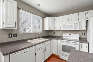 Bright, clean kitchen with abundant natural light, white cabinetry, and functional layout. Features include ample counter space, updated sink, and convenient flow for everyday living.