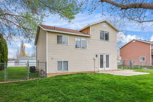 Expanded backyard view showcasing generous green space, mature trees, and private fenced yard. Features a patio off the home—perfect for summer evenings and easy indoor-outdoor living.