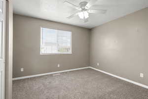 Bright upstairs bedroom with soft carpet, neutral color palette, and abundant natural light. Features a ceiling fan and flexible layout—perfect for a bedroom, nursery, or home office.