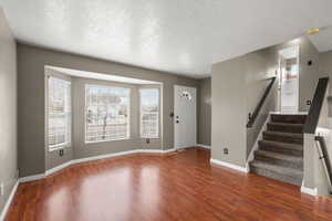Bright and open living room featuring large bay windows and beautiful flooring. An inviting space to unwind after a quick commute or a day in the mountains.