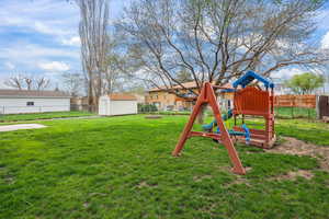 Spacious backyard designed for fun and function—featuring a playset, storage shed, and plenty of open lawn. Ideal for entertaining, play, or simply enjoying Utah’s beautiful seasons.