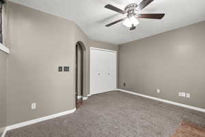 Alternate view of the family room highlighting convenient access to laundry and garage. Spacious layout, neutral finishes, and cozy carpet create a functional, everyday living space with seamless flow.