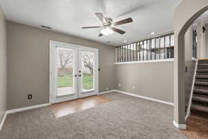 Inviting family room with direct backyard access through French doors, creating seamless indoor-outdoor living. Open sightlines to the kitchen, plush carpet, and natural light make this the perfect space for gathering, entertaining, and everyday living.