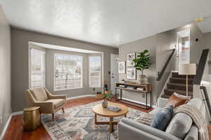 This welcoming front room features classic bay windows for natural light and has been digitally staged to highlight its modern layout.
