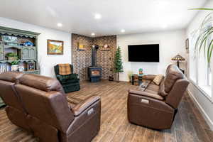 Living area featuring wood tiled floors, a wood stove, and recessed lighting