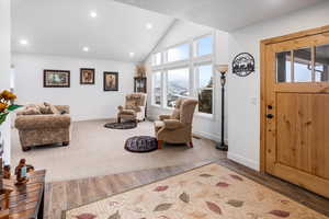 Foyer entrance with wood tiled floors, lofted ceiling, and recessed lighting