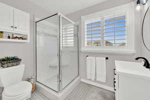 Full bathroom featuring vanity, a shower stall, and light tile patterned flooring