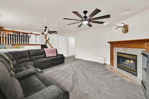 Living area with a tiled fireplace, light carpet, and light tile patterned flooring