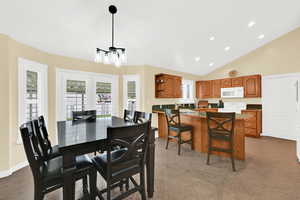 Dining area with recessed lighting, lofted ceiling, and dark tile patterned floors