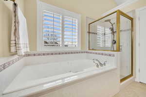 Full bath featuring a jetted tub, a shower stall, and light tile patterned floors