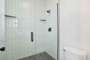 Bathroom featuring a shower stall and toilet