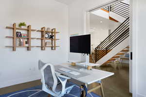 Home office with baseboards and finished concrete floors