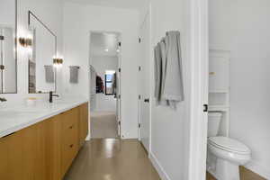 Bathroom featuring baseboards and double vanity