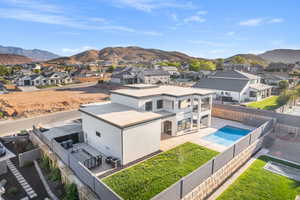 Aerial view of residential area with a mountain backdrop and a pool