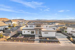 View of front of home with a residential view, stucco siding, a mountain view, concrete driveway, and a garage