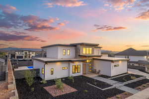 View of front of house with stucco siding, a fenced backyard, stone siding, a mountain view, and a residential view