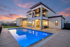 Rear view of property featuring a patio area, a fenced backyard, ceiling fan, and a balcony