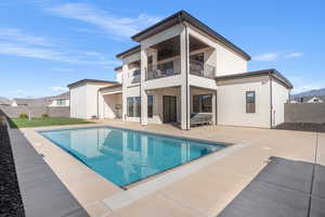 Back of property with a patio, a fenced backyard, a balcony, and stucco siding