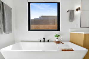 Full bath with a soaking tub and vanity