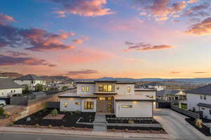 View of front of house featuring a mountain view, stucco siding, a residential view, and driveway