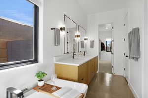 Bathroom featuring double vanity and a soaking tub