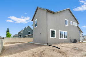 Stucco exterior with white-framed windows and a light-colored privacy fence