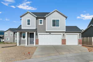 Contemporary two-story exterior featuring a mixed material facade with stucco, vertical siding, and brick accents