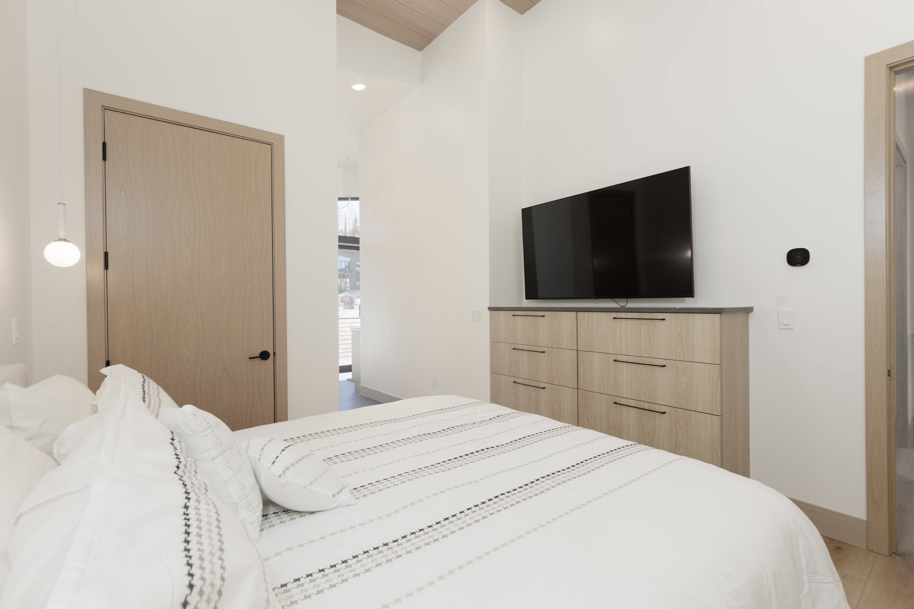 Primary bedroom with recessed lighting, wood finished floors, built-in dressers and a high wood ceiling
