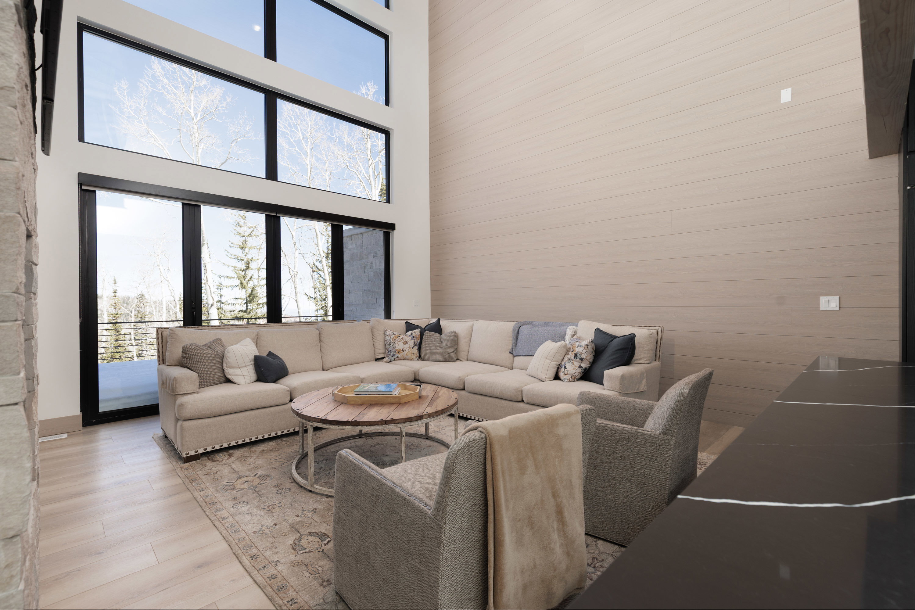 Living room featuring healthy amount of natural light, a high ceiling, and wood finished floors