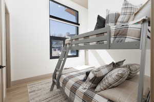 Bedroom featuring en-suite bathroom, and light wood-type flooring