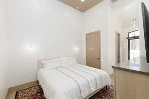 Primary bedroom with recessed lighting, wood finished floors, built-in dressers and a high wood ceiling