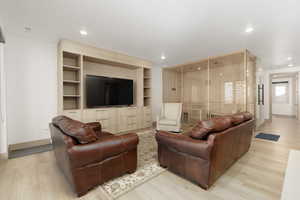 Family room featuring light wood-style floors, built in shelves, and recessed lighting