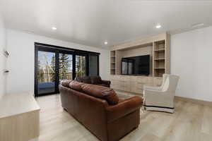 Family room featuring light wood-type flooring, built in features, and recessed lighting