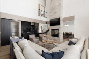 Living area featuring wood finished floors, a high ceiling, and a fireplace